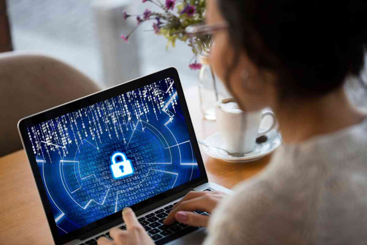 donna osserva un tablet bloccato da un lucchetto per la sicurezza informatica